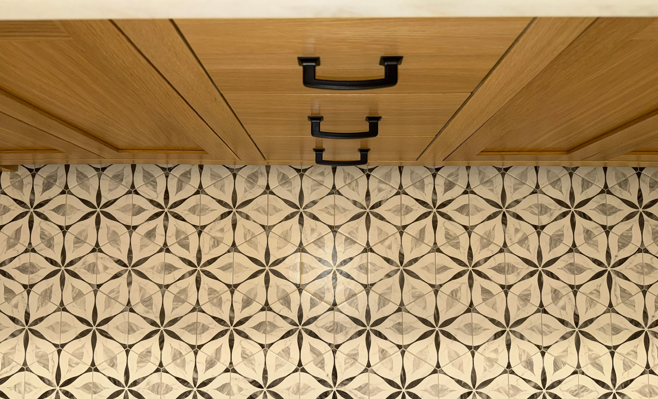 Patterned tile detail beneath cabinetry